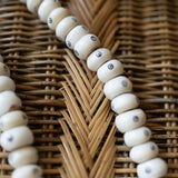 Close-up of a beaded necklace on a woven surface
