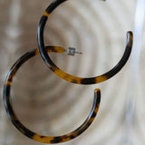 Tortoiseshell hoop earrings on a light background