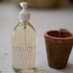 Bottle of Savon Liquid on a wooden surface with a blurred background