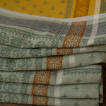 Stack of folded patterned cloths on a wooden surface
