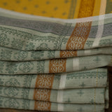 Stack of folded patterned cloths on a wooden surface