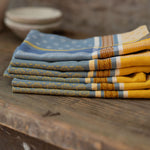 Stack of folded patterned napkins on a wooden surface