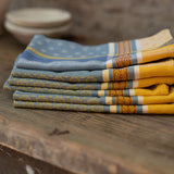 Stack of folded patterned napkins on a wooden surface