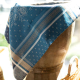 Blue patterned fabric draped over a wooden stool