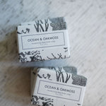 Two bars of soap labeled 'Ocean & Oakmoss' on a textured surface