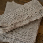 Stack of textured towels on a wooden surface