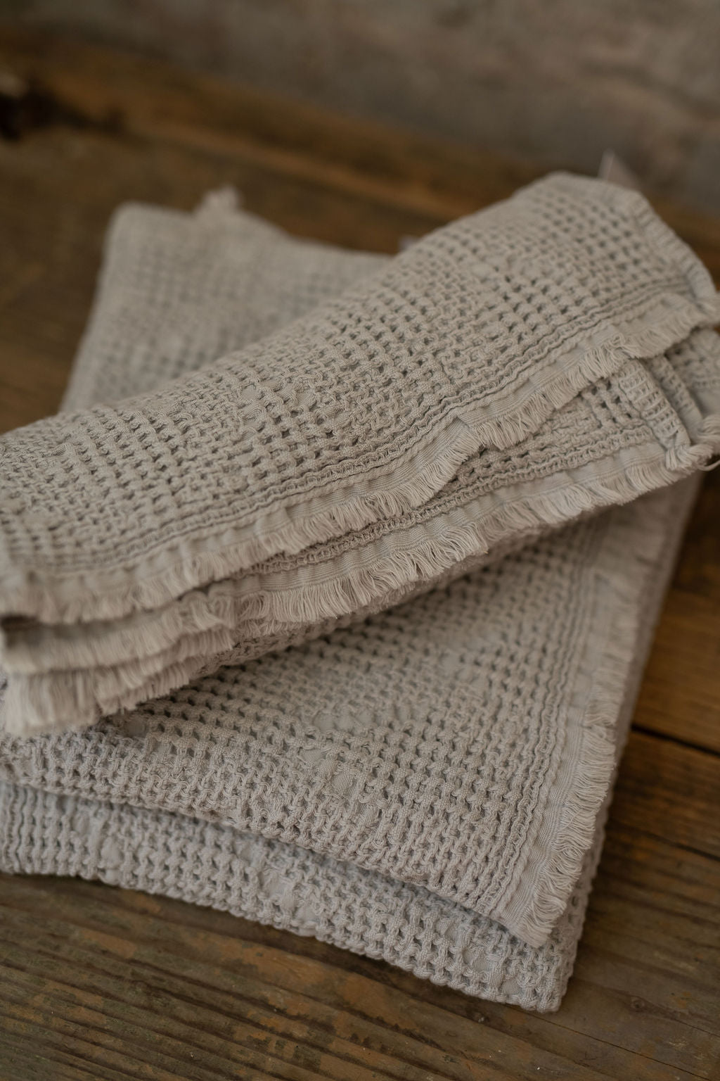 Stack of textured towels on a wooden surface
