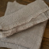 Stack of textured towels on a wooden surface