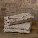 Stack of  towels on a wooden surface with a brick wall background