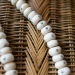 Close-up of a beaded necklace on a woven surface