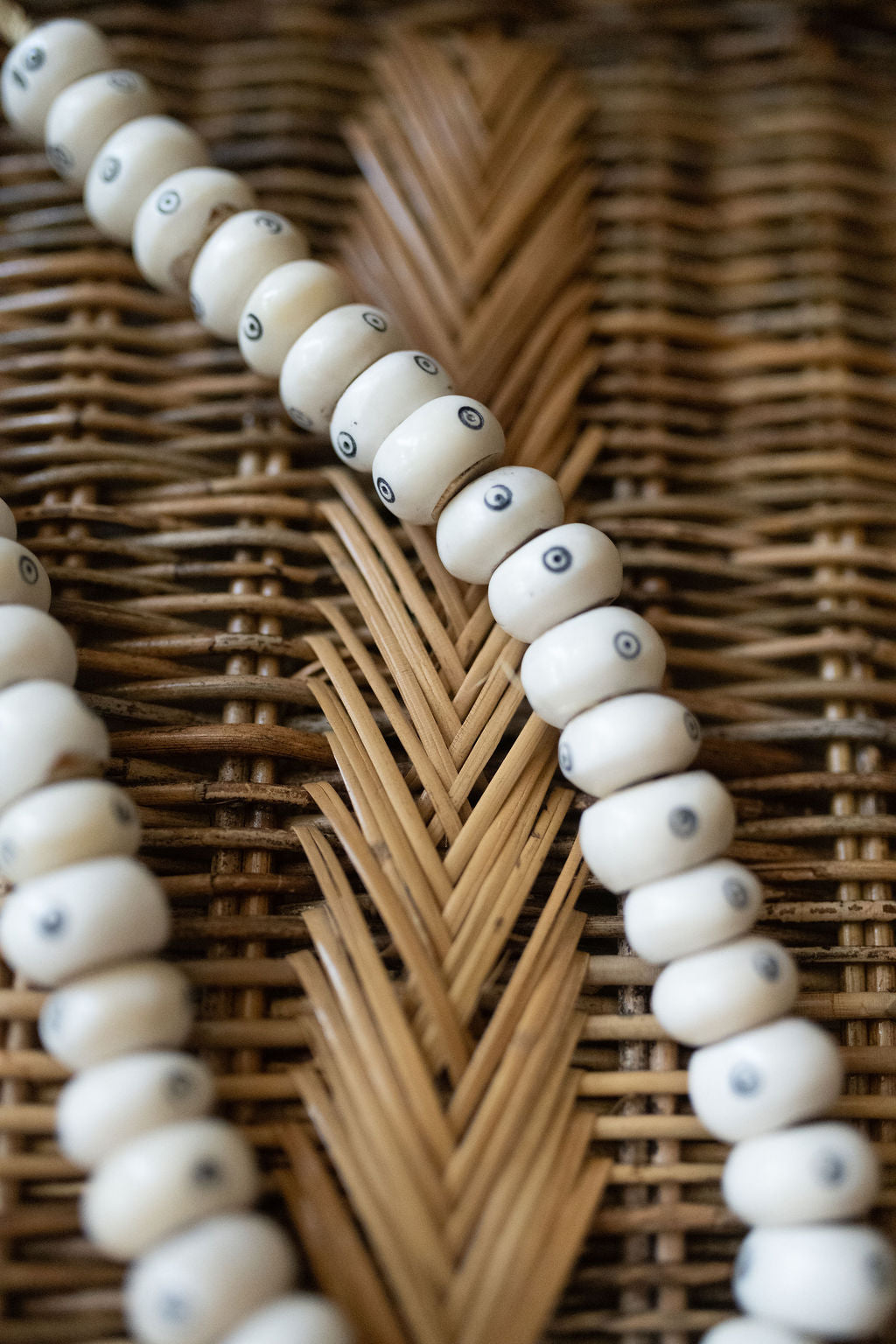 Close-up of a beaded necklace on a woven surface