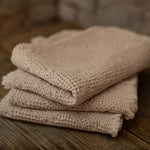 Stack of towels on a wooden surface with a stone wall background