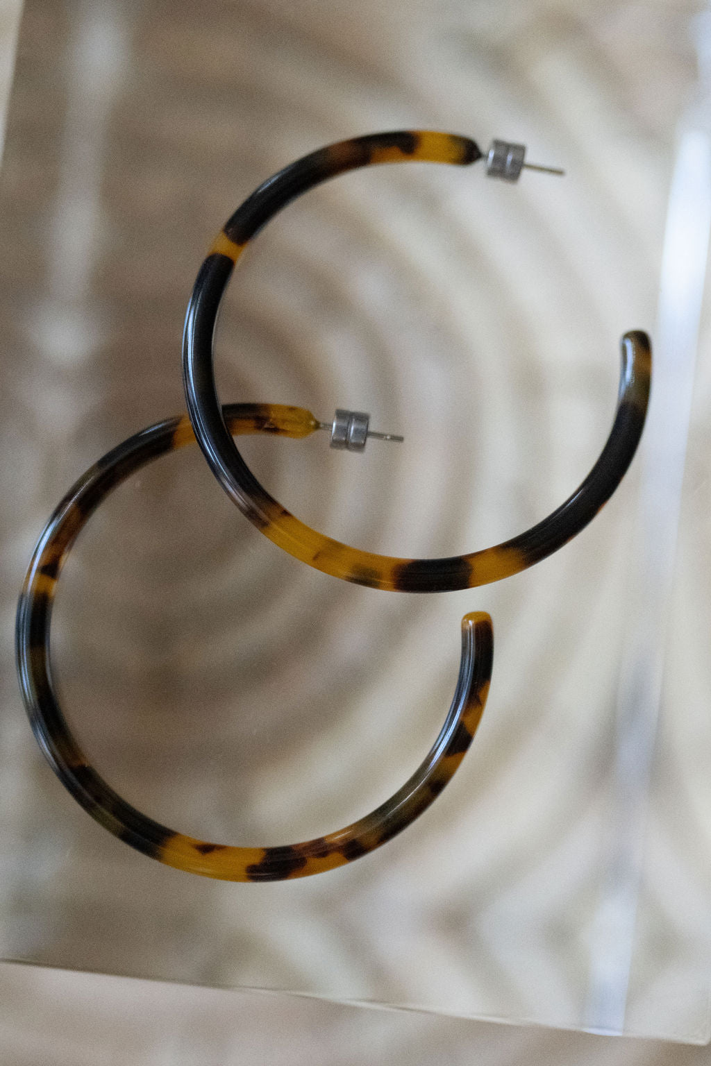 Tortoiseshell hoop earrings on a light background